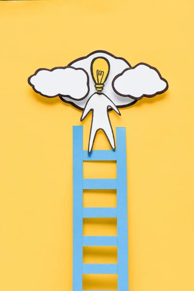 Top view of cardboard man with light bulb head climbing ladder on yellow background, ideas concept — Stock Photo