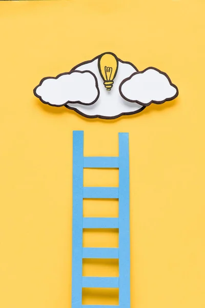Escalera de cartón con bombilla y nubes sobre fondo amarillo, concepto de ideas - foto de stock