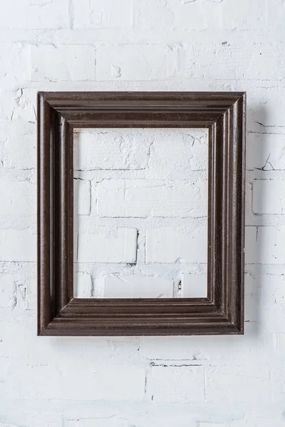 Black empty frame hanging on white brick wall — Stock Photo