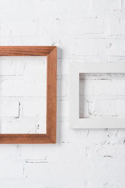 Brown and white empty frames hanging on brick wall — Stock Photo