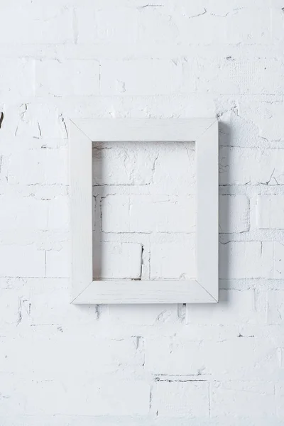 Rustic frame hanging on white brick wall — Stock Photo