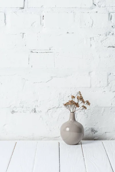 Buquê de flores secas em vaso cerâmico perto da parede de tijolo branco — Fotografia de Stock