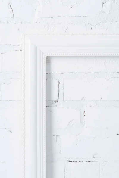 Nahaufnahme eines weißen leeren Rahmens, der an einer Ziegelwand hängt — Stockfoto