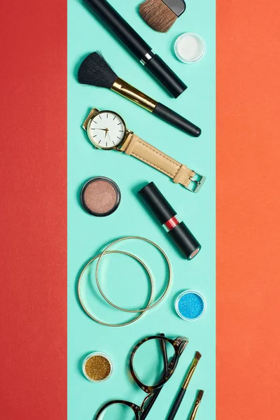 Vue de dessus du mascara, montre, rouge à lèvres, bracelets, fard à paupières, fard à joues, lunettes et pinceaux cosmétiques — Photo de stock