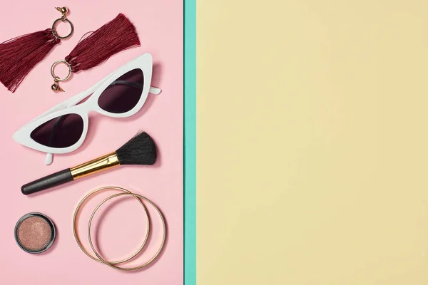 Pose plate avec rouge à lèvres, bracelets, boucles d'oreilles, pinceau cosmétique, lunettes de soleil et blush — Photo de stock