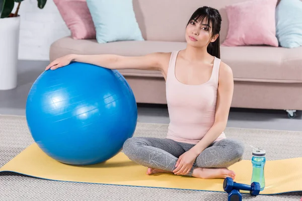 Yoga Mat Ile Uygun Topu Evde Oturan Genç Kadın Uygun — Ücretsiz Stok Fotoğraf