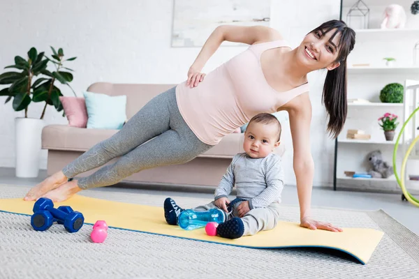 Tânără Mamă Fericită Făcând Exerciții Laterale Covorul Yoga Copilul Acasă — Fotografie, imagine de stoc