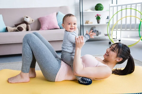 Ung Vacker Mamma Liggande Yogamatta Med Sitt Lilla Barn Hemma — Stockfoto