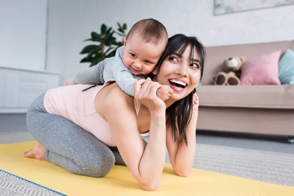 Klein Kind Meeliften Gelukkige Moeder Terwijl Permanent Yoga Mat Thuis — Stockfoto