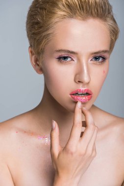 Dudakları çok dokunaklı ve gri izole kamera bakarak pırıltılı makyaj ile güzel kadın