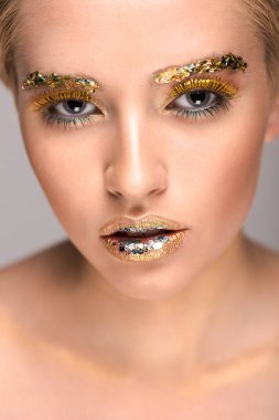 kameraya bakarak yüzündeki altın glitter çekici kadın