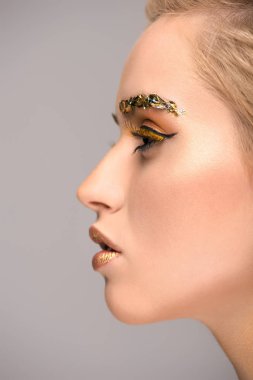 gri izole altın pırıltılı makyaj ile çekici kadın yan görünüm