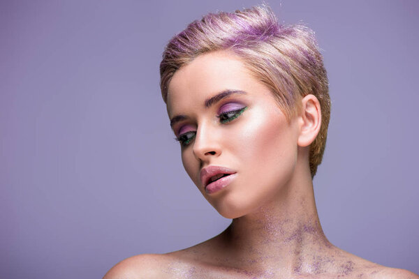 attractive woman with violet glitter on neck and short violet hair isolated on violet