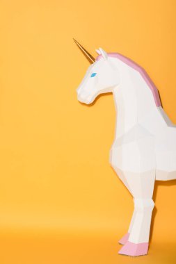 partial view of decorative unicorn standing on yellow background  clipart