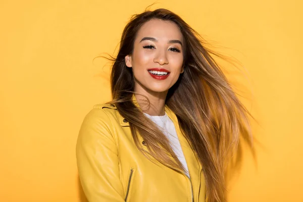 young attractive female model posing on yellow background