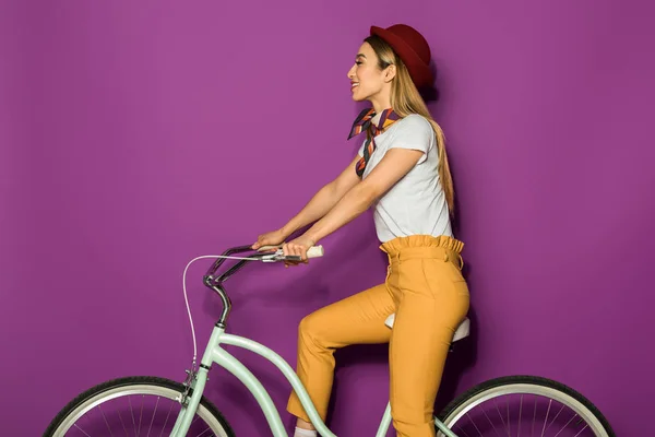 Attractive Smiling Stylish Girl Sitting Bicycle Looking Away Isolated Violet — Free Stock Photo