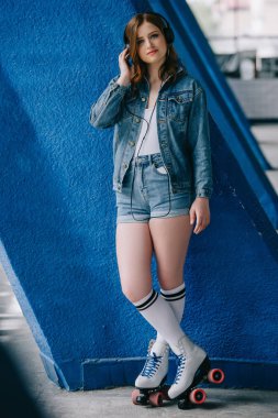 denim giyim ve retro tekerlekli paten kulaklık müzik dinleme genç moda kadın