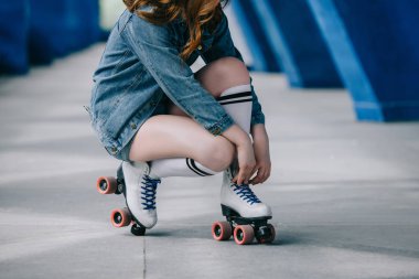 denim giysi, yüksek çorap ve retro tekerlekli paten içinde şık kadın kırpılmış atış