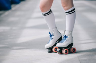 partial view of woman in white high socks and retro roller skates clipart