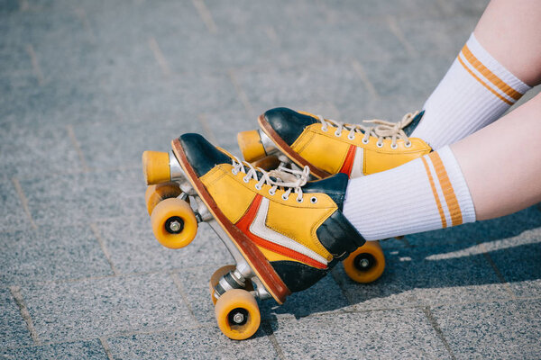 close-up partial view of female legs in vintage roller skates