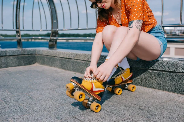 ビンテージのローラー スケート靴を身に着けているサングラスでスタイリッシュな女の子のショットをトリミング — ストック写真