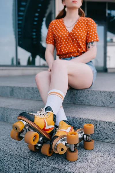階段の上に座ってローラー スケートの女の子のショットをトリミング  — 無料ストックフォト