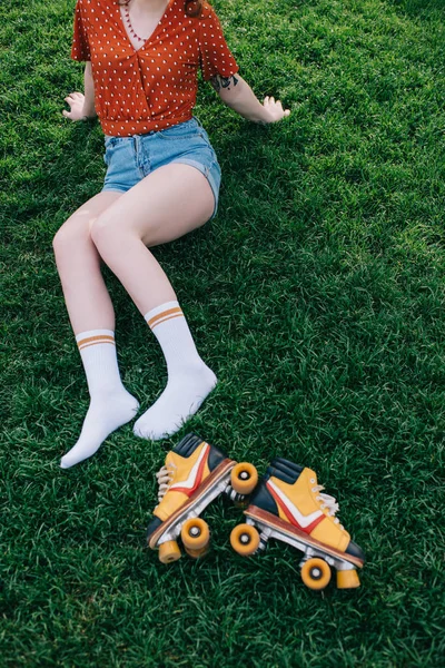 Tiro Cortado Menina Calções Jeans Meias Descansando Grama Com Patins — Fotografia de Stock