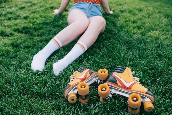 靴下と芝生の上のビンテージのローラー スケートで女性の足のクロップ撮影  — 無料ストックフォト