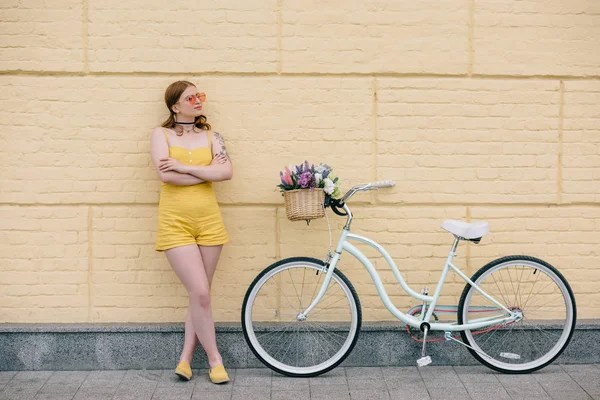 Stylowa Dziewczyna Okulary Odwracając Stojąc Skrzyżowanymi Ramionami Pobliżu Rower — Zdjęcie stockowe