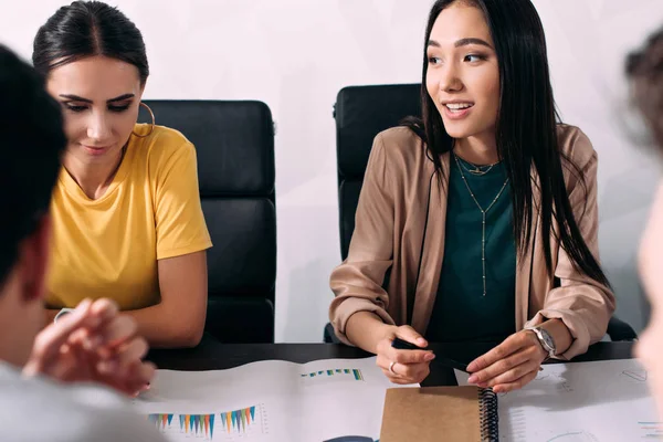 Donne Affari Multiculturali Sedute Tavola Con Grafici Durante Riunione Lavoro — Foto Stock