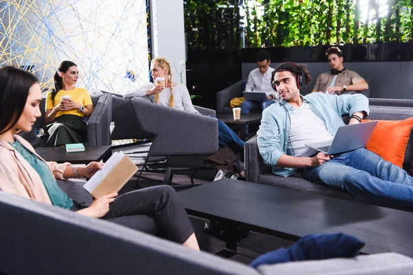 group of multicultural business people working and talking at modern coworking office