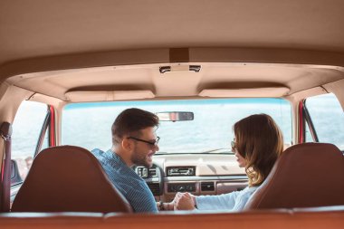 beautiful happy couple sitting in car during road trip clipart