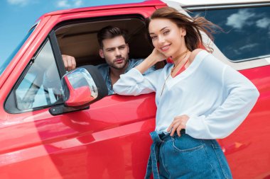 çekici gülümseyen kız erkek arkadaşı ile kırmızı araba yakınındaki ayakta