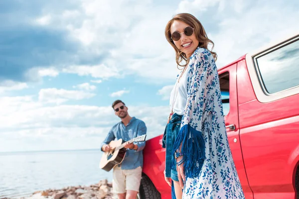 Joven Tocando Guitarra Acústica Cerca Del Coche Con Una Novia —  Fotos de Stock