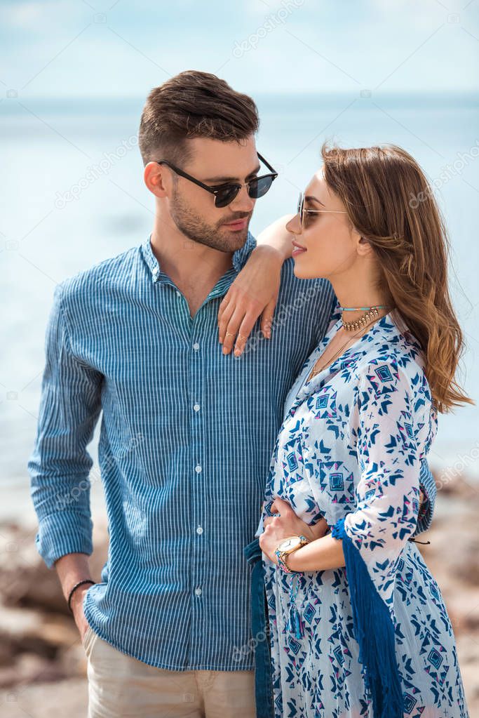 beautiful young couple in sunglasses hugging together