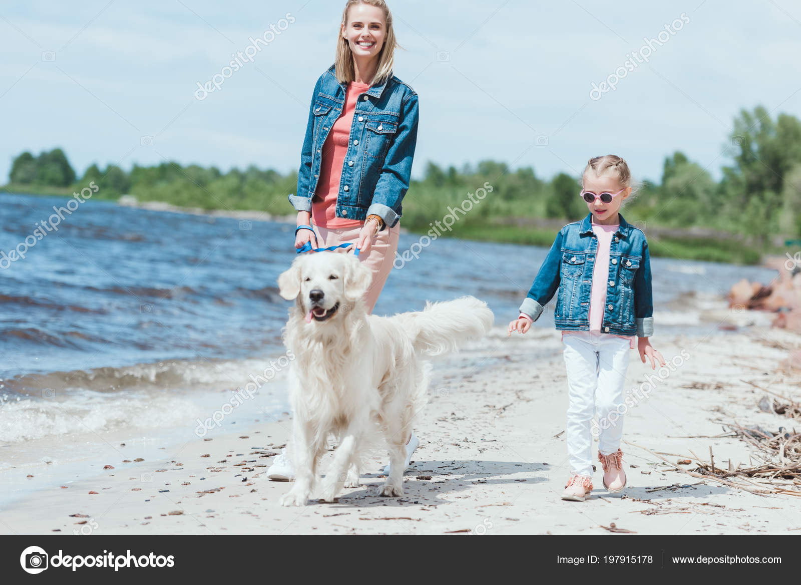 Felice famiglia a piedi con cane golden retriever sulla riva del mare — Immagine stock gratuita