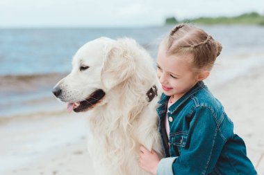  çok güzel çocuk sarılma golden retriever köpek deniz kıyısında