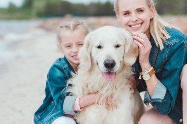 Anne ve kızı ile golden retriever Köpek gülümsüyor  