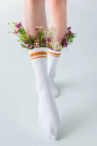 女孩在袜子与美丽的花朵走在灰色的照片被裁剪拍摄 — 图库照片