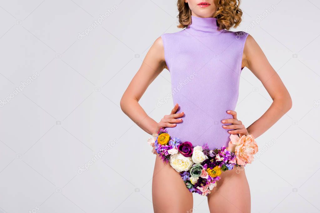 cropped shot of girl in panties made of flowers standing with hands on waist isolated on grey