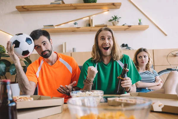 Sonriente Joven Verde Ventilador Camiseta Celebrando Mientras Sus Amigos Molestos — Foto de Stock