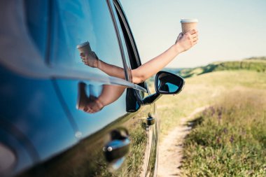 atış el ile kağıt bardak kahve kırsal alandaki araba penceresinden dışarı yaslanmış kadının kırpılmış 