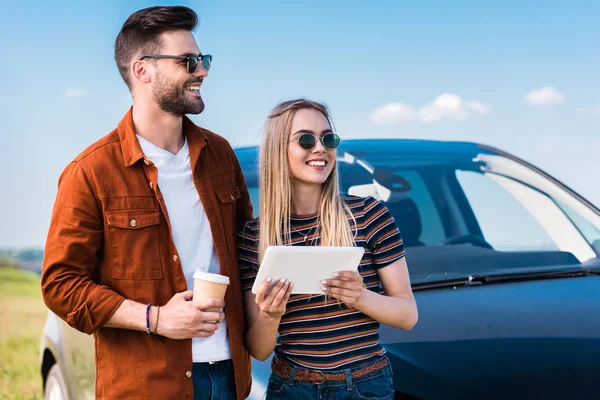 Stylish Couple Sunglasses Standing Coffee Cup Digital Tablet Car — Stock Photo, Image