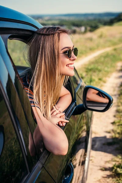 Zijaanzicht Van Stijlvolle Vrouw Zonnebril Leunend Uit Van Autoruit Landelijke — Stockfoto