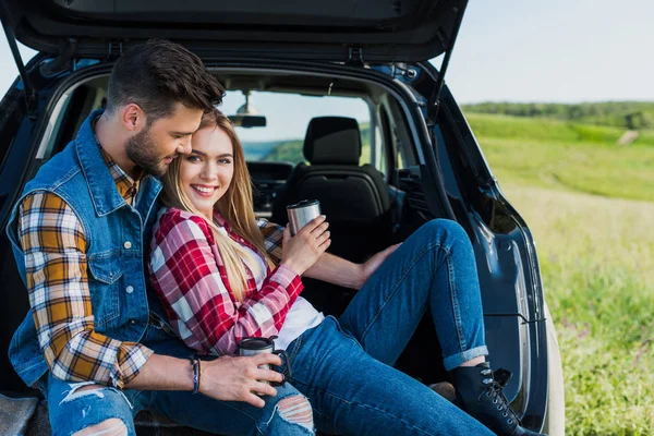 Casal Viajantes Elegantes Com Xícaras Café Sentado Porta Malas Carro — Fotografia de Stock