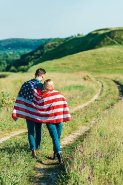 Genç çift Amerikan bayrağı ile kırsal çayır, bağımsızlık günü kavramı üzerinde dikiz