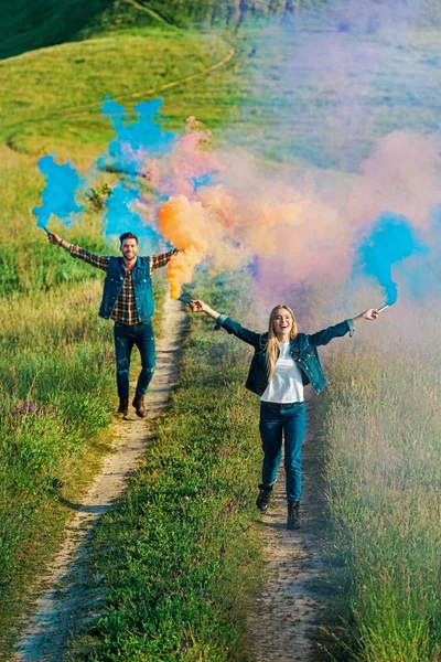 Vista Ángulo Alto Pareja Joven Sosteniendo Bombas Humo Colores Prado — Foto de Stock