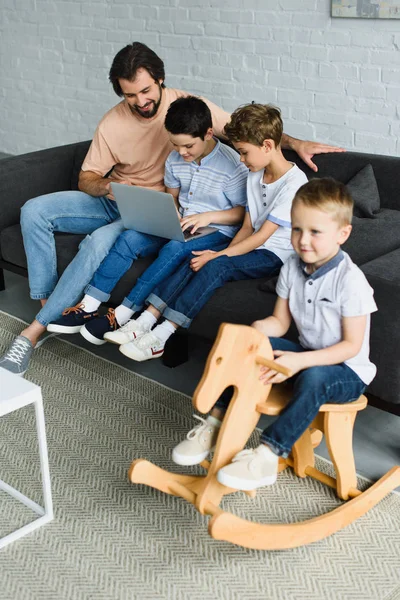 Mann Und Kinder Der Nähe Mit Laptop Zusammen Auf Sofa — kostenloses Stockfoto