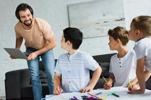 Smiling Man Laptop Looking Sons Drawing Pictures Wit Colorful Pencils — Stock Photo, Image