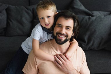 evde kanepe üzerinde bir küçük oğlu kucaklama mutlu baba yüksek açılı görünüş